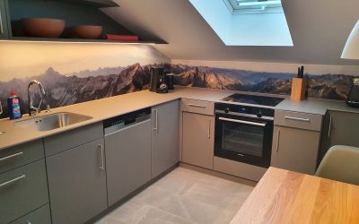 Küch mit bedruckter Glasplatte als Rückwand und Arbeitsplatte aus Keramik.